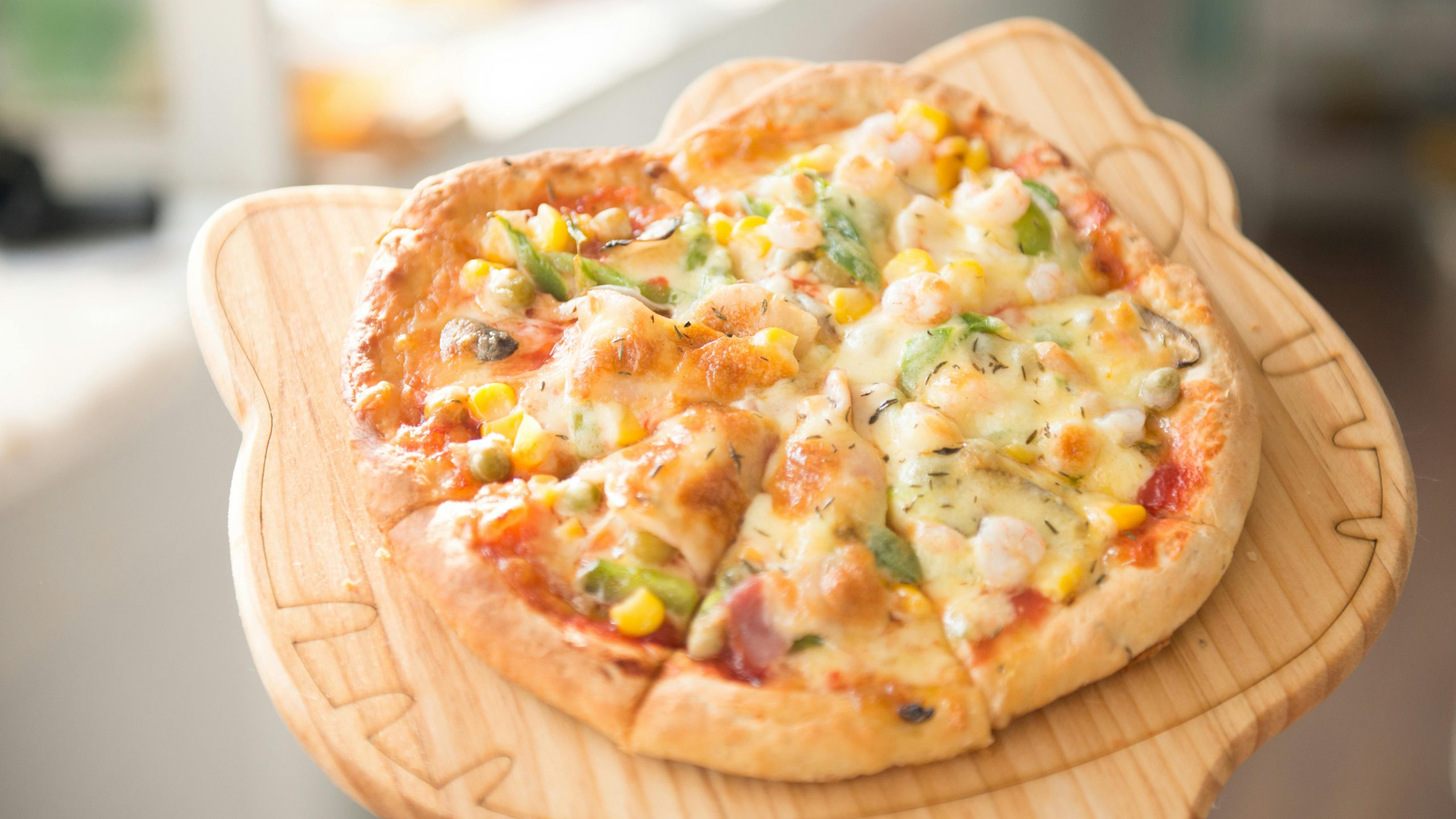 Fresh homemade vegetable pizza topped with cheese and served on a wooden board, perfect for a gourmet meal.